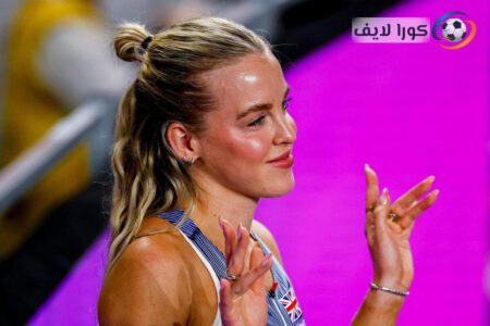 البطلة الأولمبية كيلي هودجكينسون تبتسم في مضمار ألعاب القوى، مع شعار ملعب لندن في الخلفية.