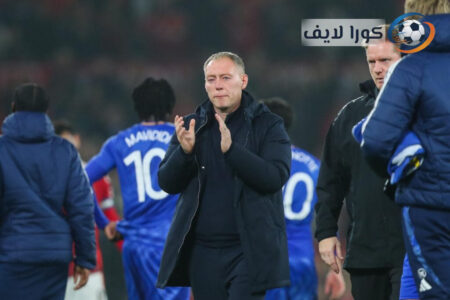 ستيف كوبر مدرب بروندبي يتحدث في مؤتمر صحفي مع شعار النادي في الخلفية.